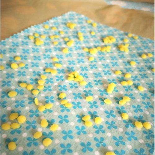 Foto zum zweiten Schritt für ein selbstgemachtes Bienenwachstuch: Wachspastillen auf einem Tuch