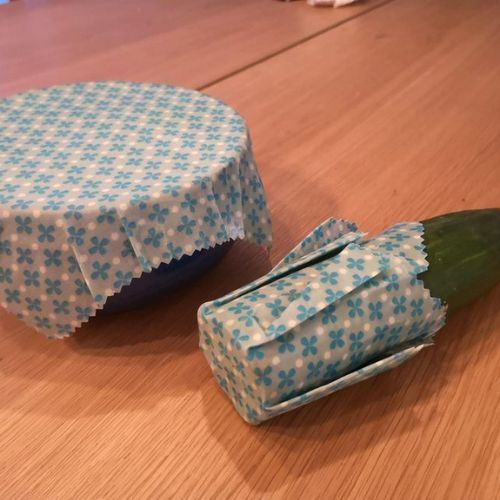 Foto zum vierten Schritt für ein selbstgemachtes Bienenwachstuch: Fertige Wachstücher auf Schüssel und angeschnittener Gurke