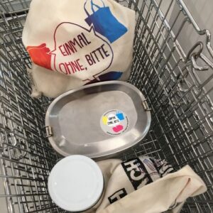 Einkaufskorb mit eigenen Behältnissen wie Stoffbeuteln und Edelstahldose mit Verlinkung zur Seite „Dein Einkauf“